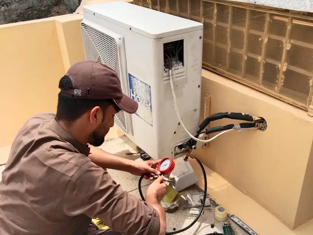 HVAC technician maintaining an outdoor AC unit